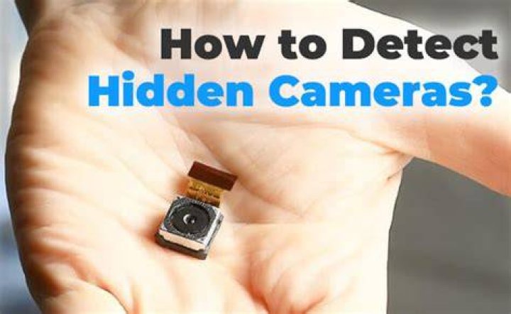 How can you find a hidden camera with a flashlight?